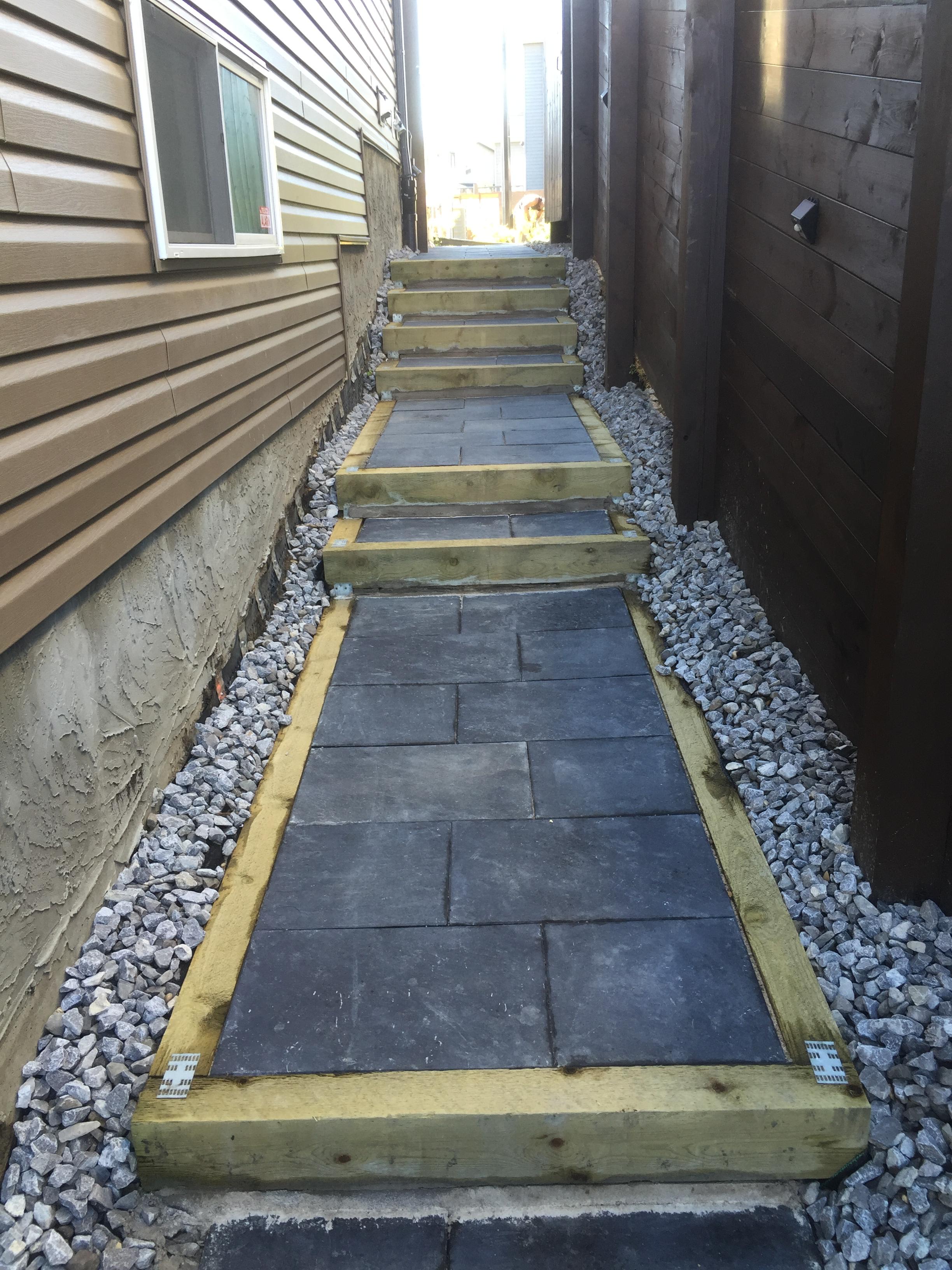 Slate tile pathway with timber step risers and gravel surround in side yard